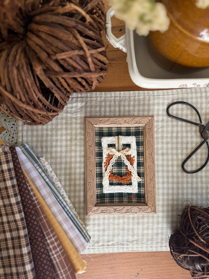 Large White Wicker Frame with Fall Wreath on Green Plaid Fabric in Wooden Vine Frame