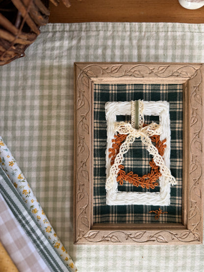 Large White Wicker Frame with Fall Wreath on Green Plaid Fabric in Wooden Vine Frame