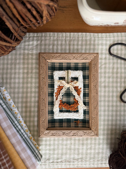 Large White Wicker Frame with Fall Wreath on Green Plaid Fabric in Wooden Vine Frame